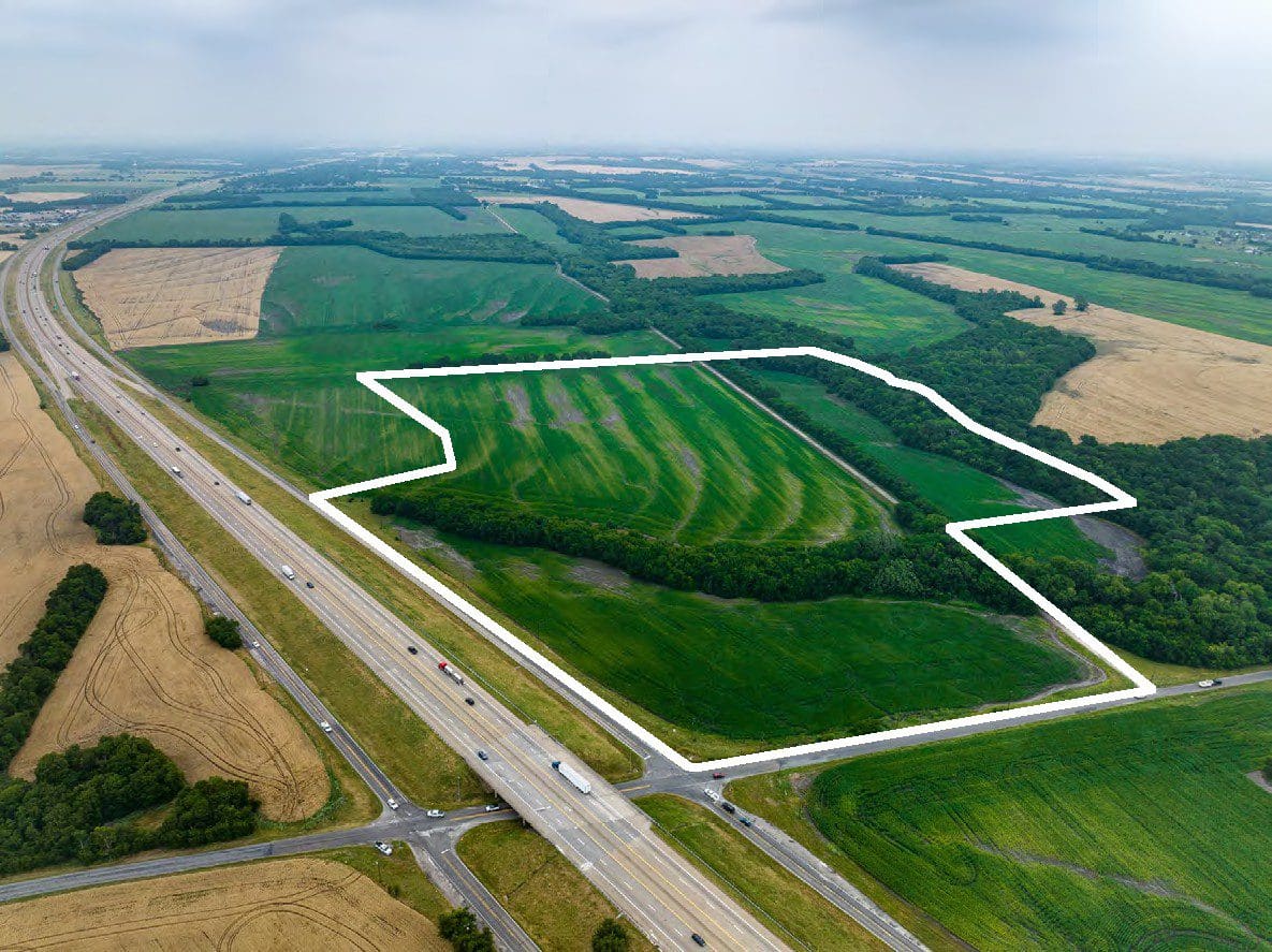 Aerial view of bordered farmland by highway